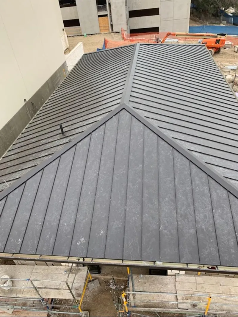 Commercial metal roof construction with crane equipment in Mendota